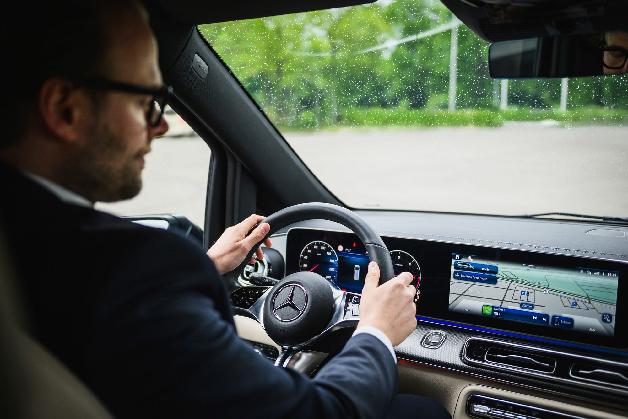 Chauffeur im Anzug am Steuer eines Mercedes-Benz